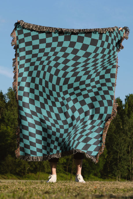 Black and blue wavy checkered woven throw blanket with a bold geometric pattern.

