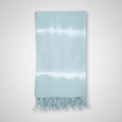 Light blue towel with white fringe on a light gray background