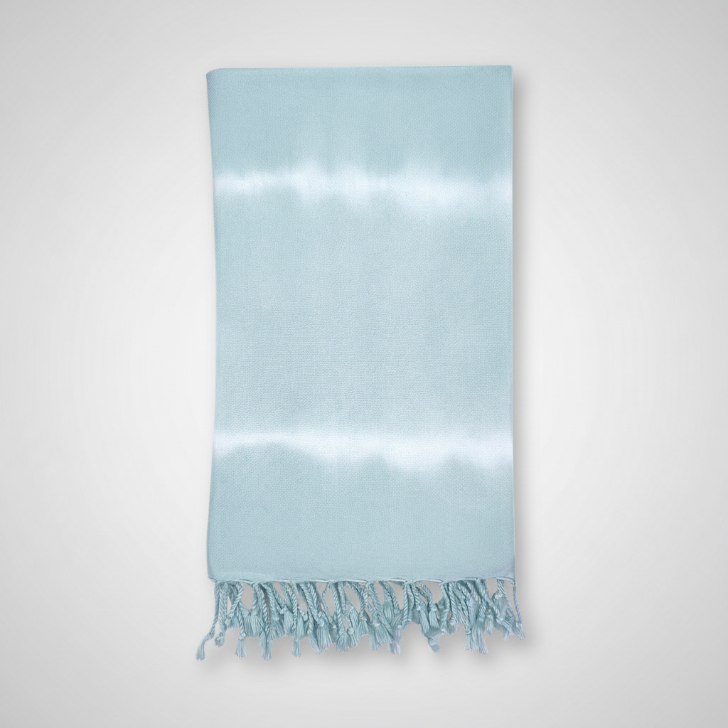 Light blue towel with white fringe on a light gray background