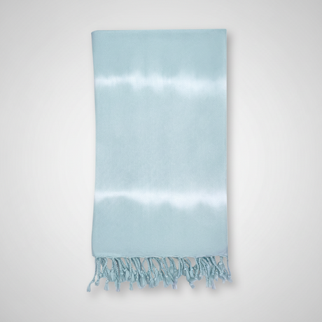 Light blue towel with white fringe on a light gray background