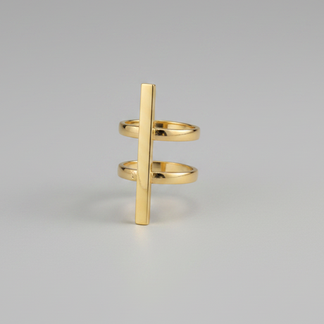 Gold ring with a vertical bar design on a gray background