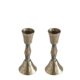 Two metallic candle holders on a white background
