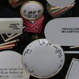Collection of decorative plates with humorous sayings on a dark surface