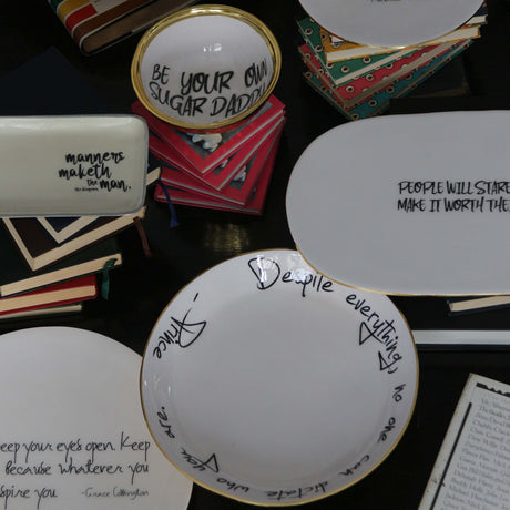 Collection of decorative plates with humorous sayings on a dark surface