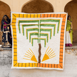Quilt with geometric design held by a person against an architectural background