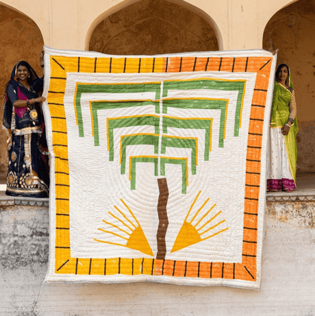 Quilt with geometric design held by a person against an architectural background