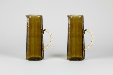 Two glass pitchers with white handles on a light gray background