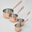 Set of copper cookware with handles on a white background
