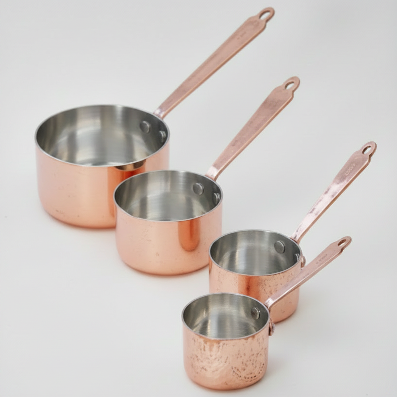 Set of copper cookware with handles on a white background