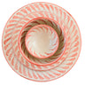 Coral-colored ceramic plates and bowls on a light surface with a spoon and napkin.