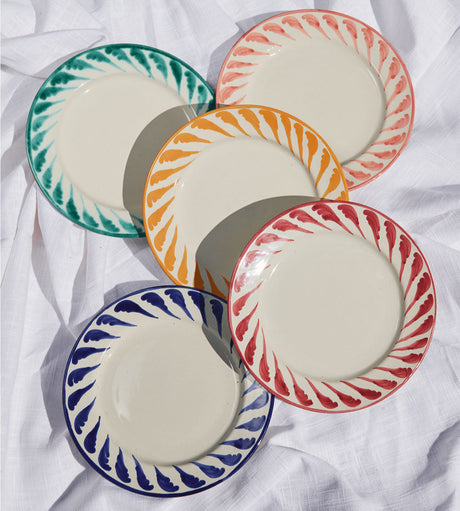 Set of colorful ceramic plates on a white fabric background