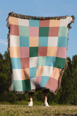 Plaid-inspired cotton woven throw blanket featuring a modern checkered pattern.
