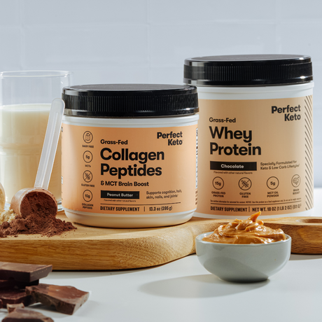 Two containers of Perfect Keto products on a white surface with a wooden board and bowl.