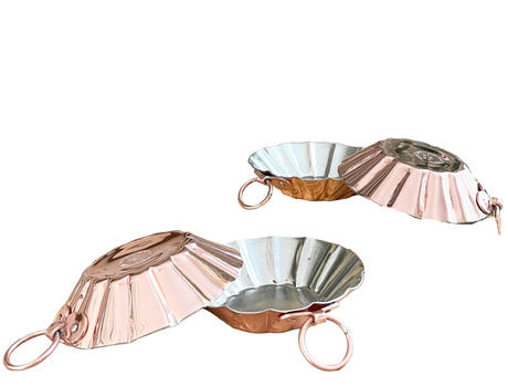 Set of four copper tartlet molds on a white background