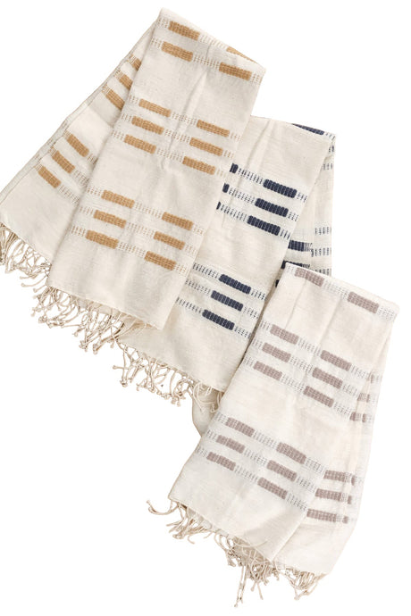 Three woven towels with striped patterns on a wooden surface