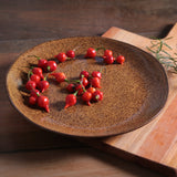 Red chili peppers on a textured ceramic plate with a wooden background