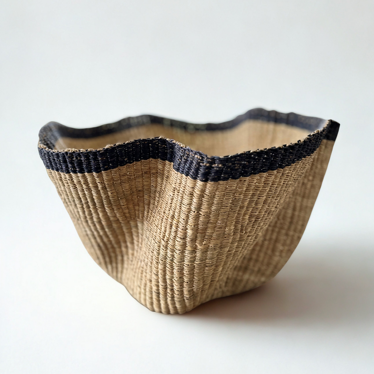 Woven basket with black rim on a white background