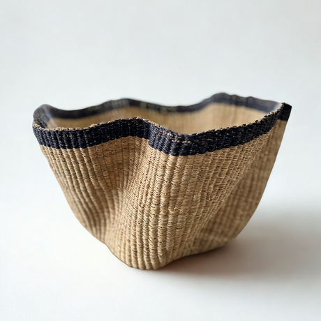 Woven basket with black rim on a white background