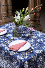 Set table with floral arrangement on a blue patterned tablecloth