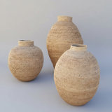 Three woven vases of different sizes on a light gray background