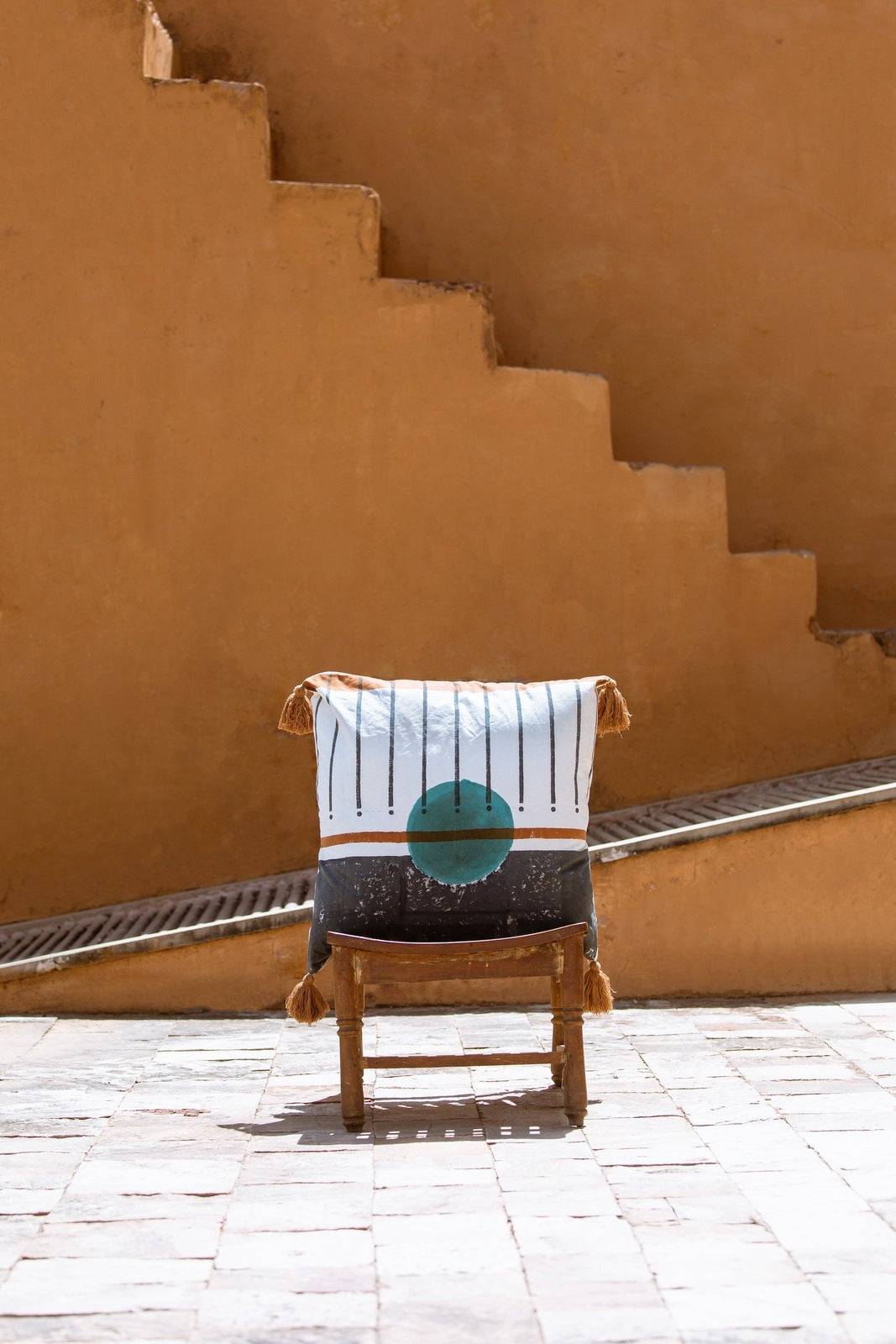 Chair with a striped towel featuring a green circle against a beige wall.