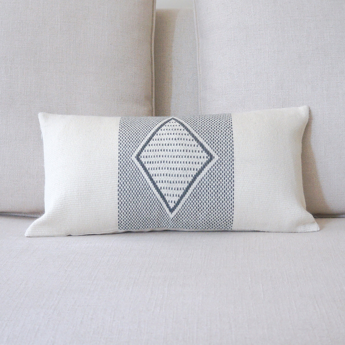 Decorative pillow with geometric pattern on a light gray sofa
