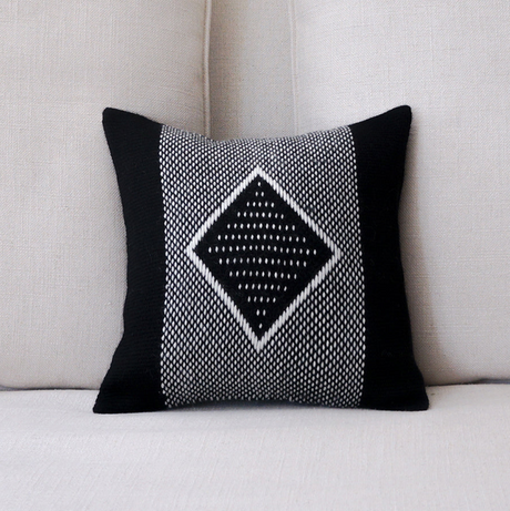 Decorative pillow with black and white pattern on a beige sofa