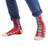 Red socks with blue polka dots worn with blue pants on a white background
