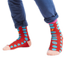 Red socks with blue polka dots worn with blue pants on a white background