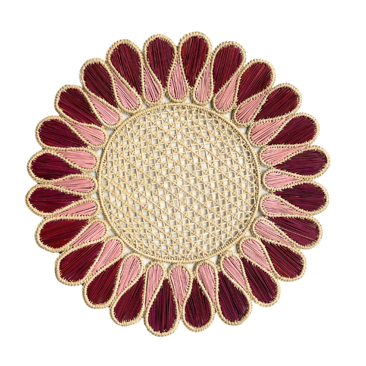 Decorative woven placemat with red and pink petal-like design on a white background