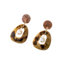 Pair of tortoiseshell earrings with pearl center on a white background