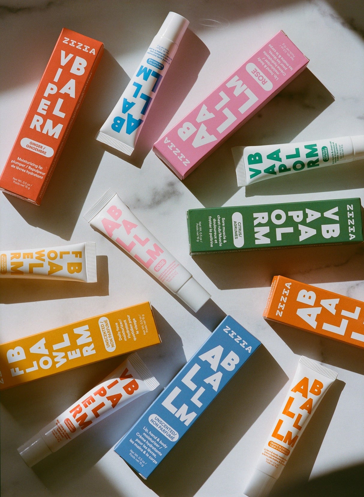 Various colorful lip balm containers and tubes on a light background