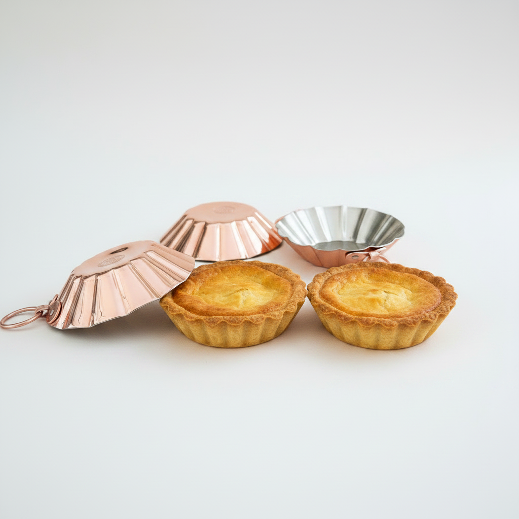 Two small pies in metal pie protectors on a white background