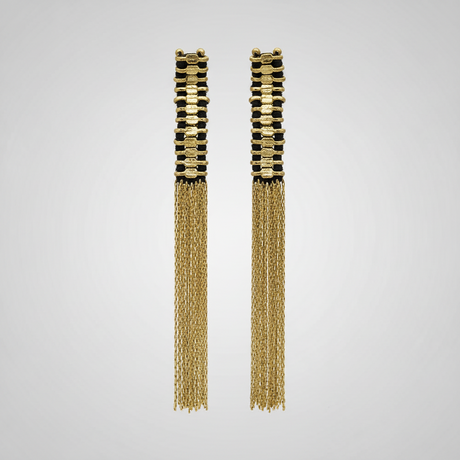 Pair of gold tassel earrings on a light gray background