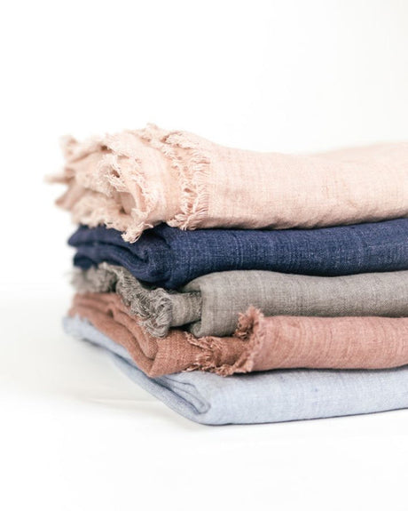 Stack of folded fabric swatches in various colors on a white background