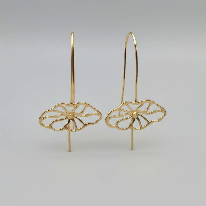 Gold floral earrings on a gray background