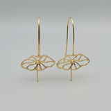 Gold floral earrings on a gray background