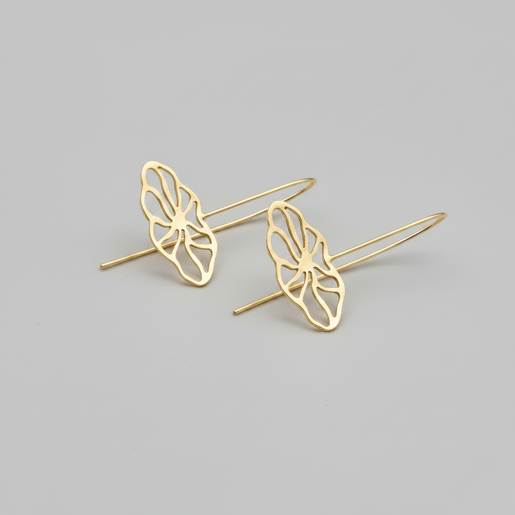 Gold flower-shaped earrings on a gray background