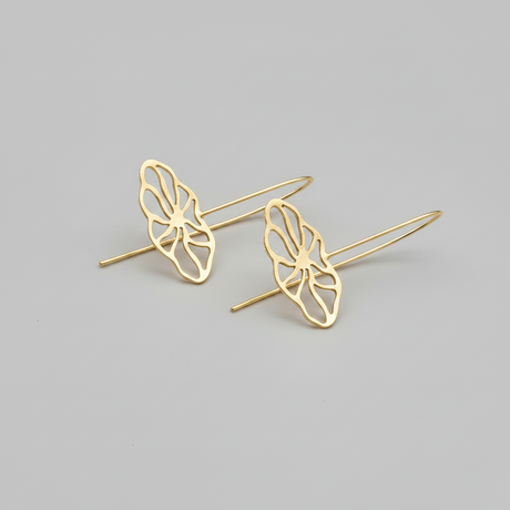 Gold flower-shaped earrings on a gray background