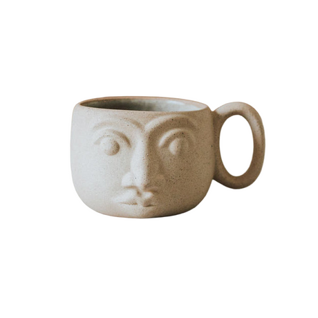 Ceramic mug with face design on a white background