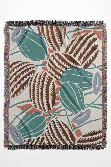 Desert-inspired woven throw blanket with cactus and floral patterns in earthy green, brown, and beige.
