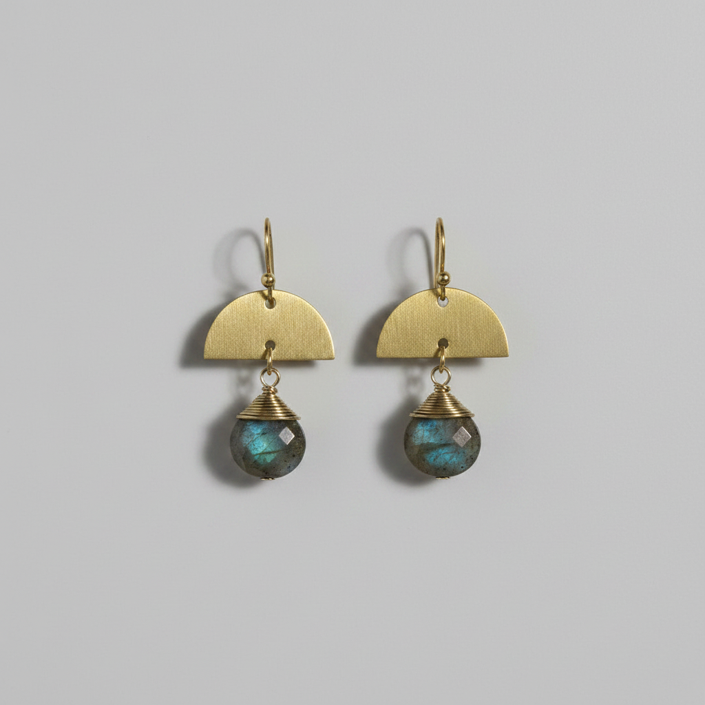 Pair of gold earrings with labradorite stones on a gray background