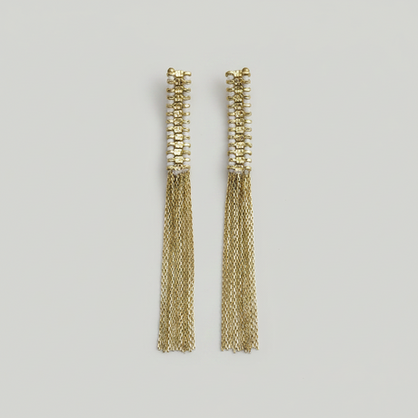 Pair of gold tassel earrings on a light gray background