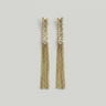 Pair of gold tassel earrings on a light gray background