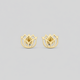Gold earrings on a light gray background