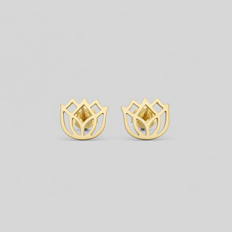Gold earrings on a light gray background