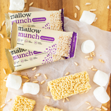 Mallow Munch marshmallow bars on a wooden surface with scattered marshmallows and cereal pieces.