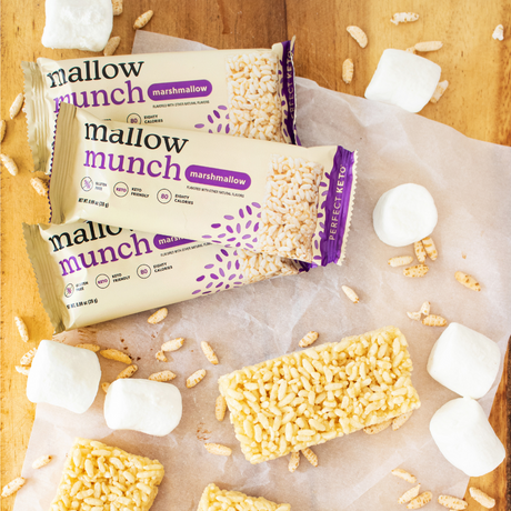 Mallow Munch marshmallow bars on a wooden surface with scattered marshmallows and cereal pieces.