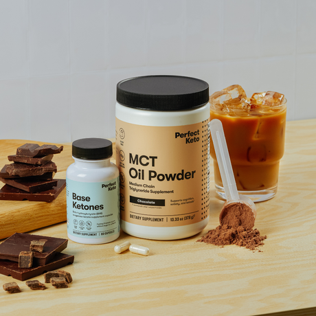 Supplement products including MCT oil powder and base ketones on a wooden surface with chocolate and iced coffee.