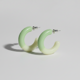 Green hoop earrings on a light gray background